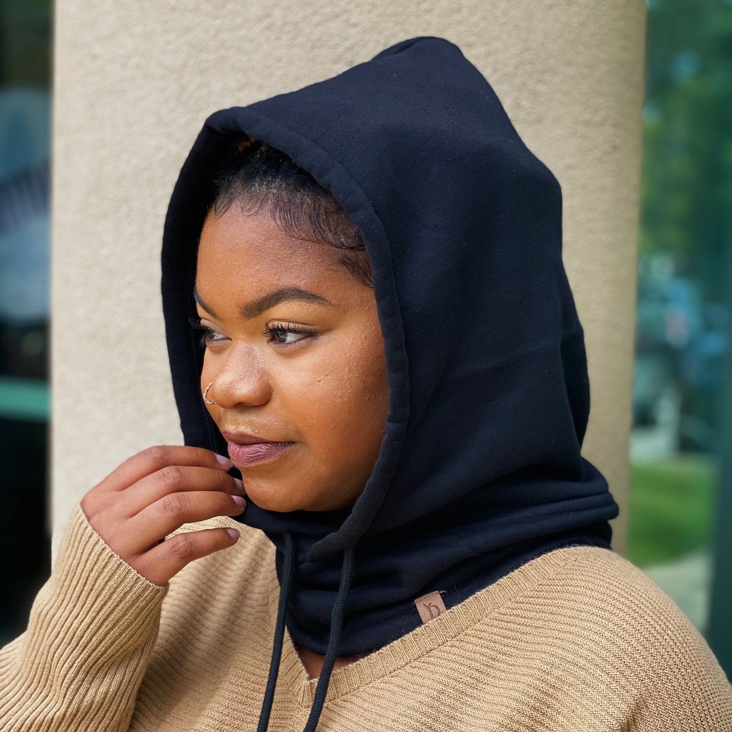 Person wearing a stylish navy blue hooded sweatshirt, showcasing a warm beige knit sweater underneath, perfect for casual fall outfits.