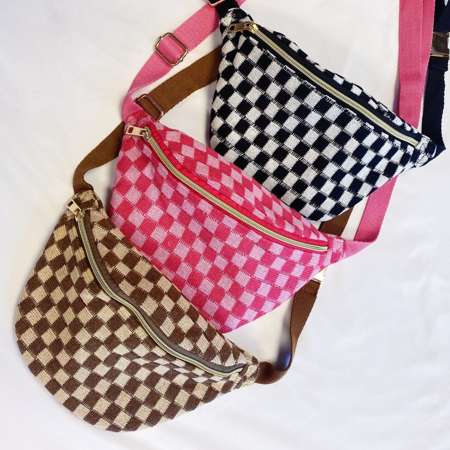 Three stylish checkered fanny packs in pink, black, and brown colors, featuring gold zippers and adjustable straps, displayed on a white background.