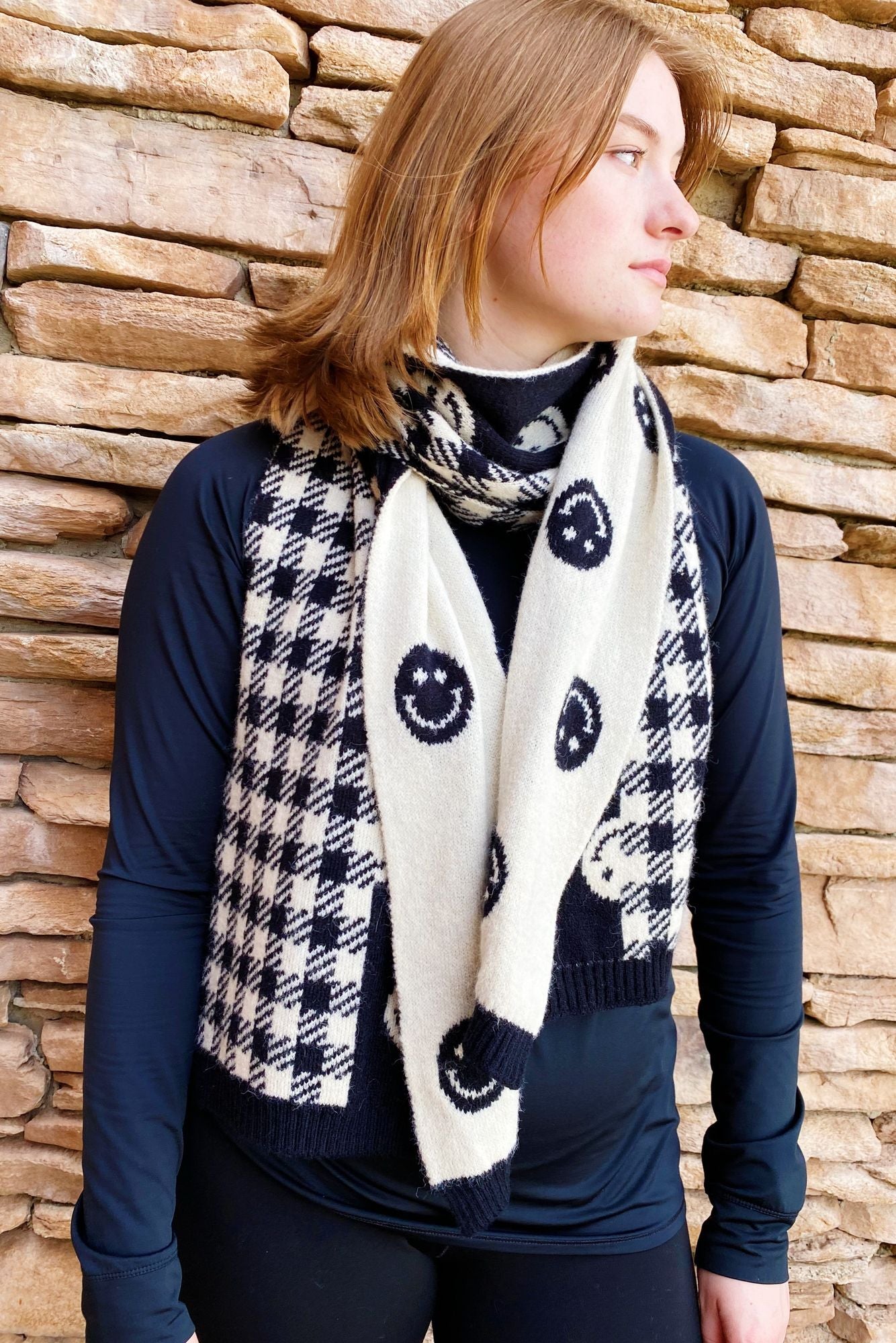 Fashionable unisex scarf featuring a trendy black and white houndstooth pattern paired with playful smiley faces, perfect for adding warmth and style to any outfit.