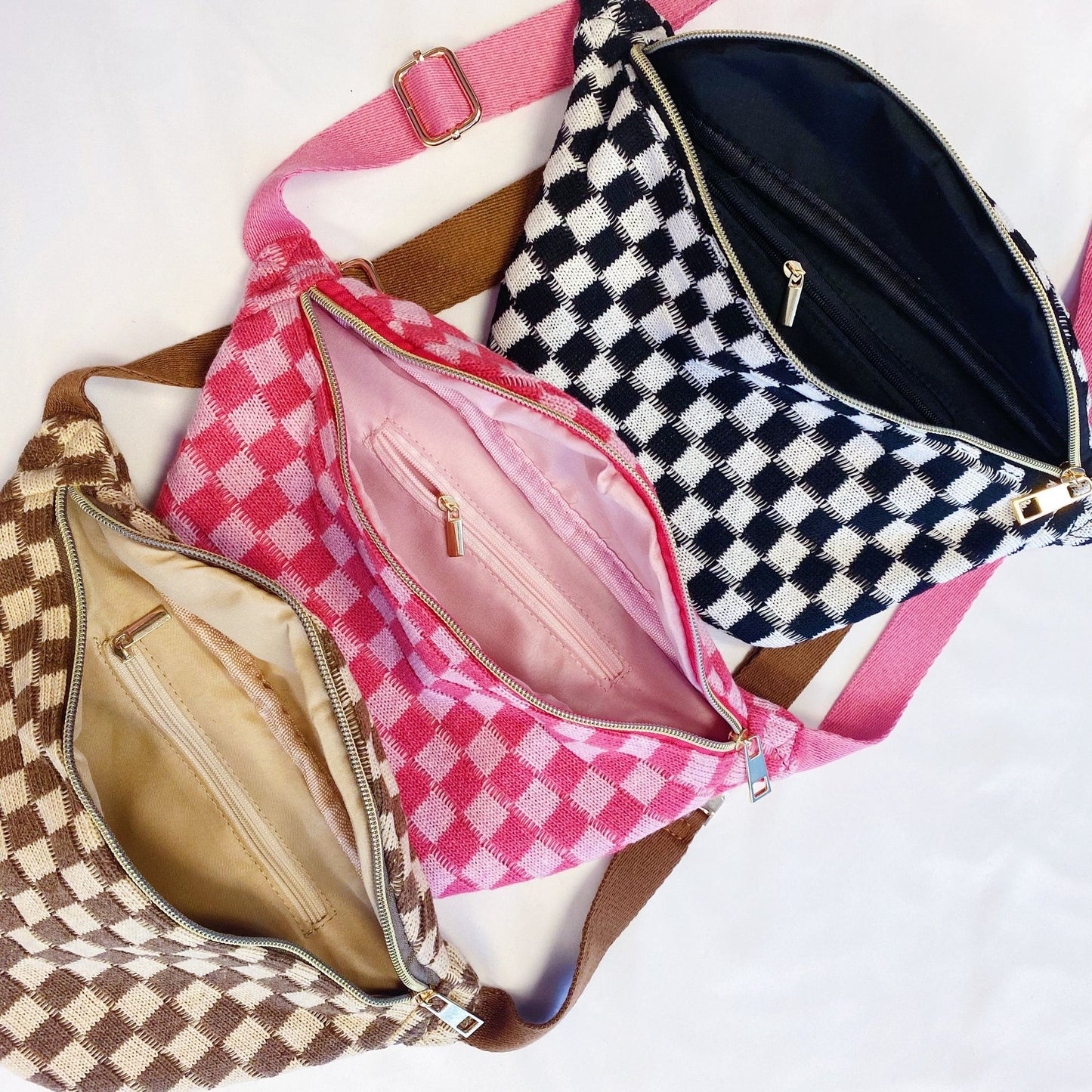 Three stylish checkered handbags in pink, black, and brown, showcasing their spacious interiors and zippers, perfect for fashion-conscious individuals.