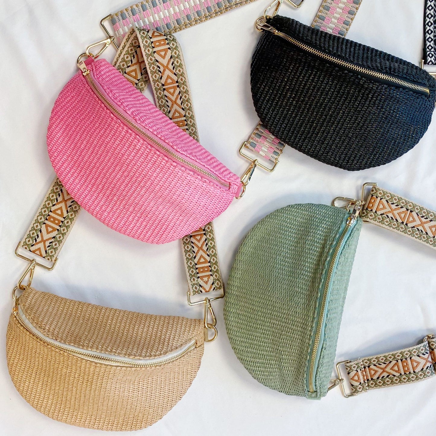 Colorful collection of stylish woven crossbody bags in pink, black, beige, and green, featuring decorative straps and gold zippers, arranged on a light background.