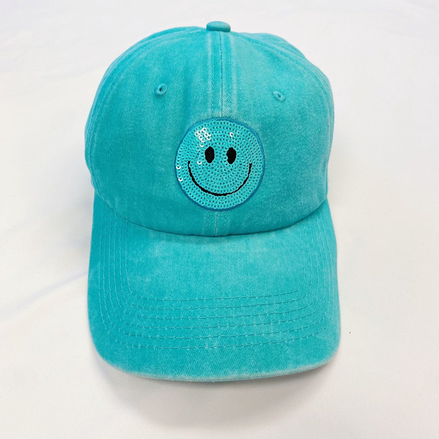 Turquoise baseball cap featuring a sparkling sequined smiley face patch on the front, perfect for adding a cheerful touch to casual outfits.