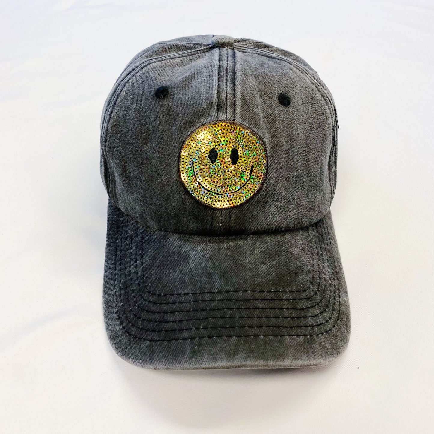 Gray baseball cap with a shiny, colorful smiley face emblem on the front, perfect for adding a cheerful touch to any outfit.