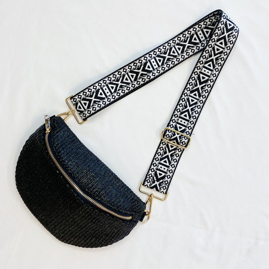 Stylish black woven crossbody bag with a decorative geometric patterned strap and gold hardware, perfect for a chic everyday look.