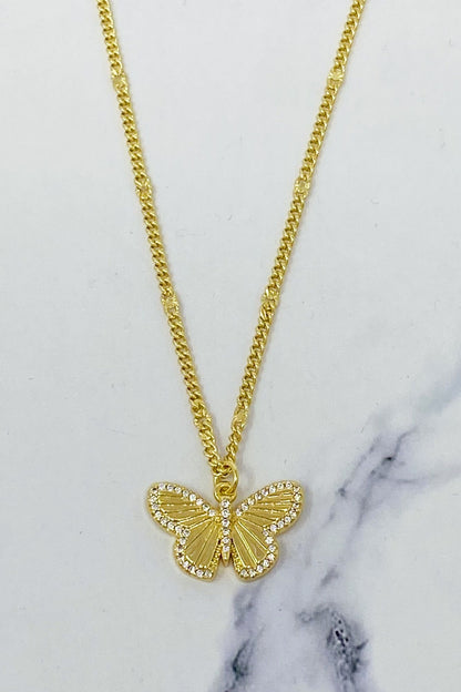 Gold butterfly pendant necklace with sparkling rhinestones on a dainty chain, set against a marble background.