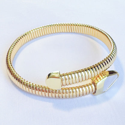 Elegant gold spiral bangle bracelet with a flexible design and a modern angular clasp, perfect for adding a stylish touch to any outfit.