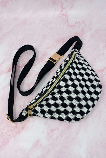 Black and white checkered fanny pack with a gold zipper and adjustable strap, set against a soft pink background.