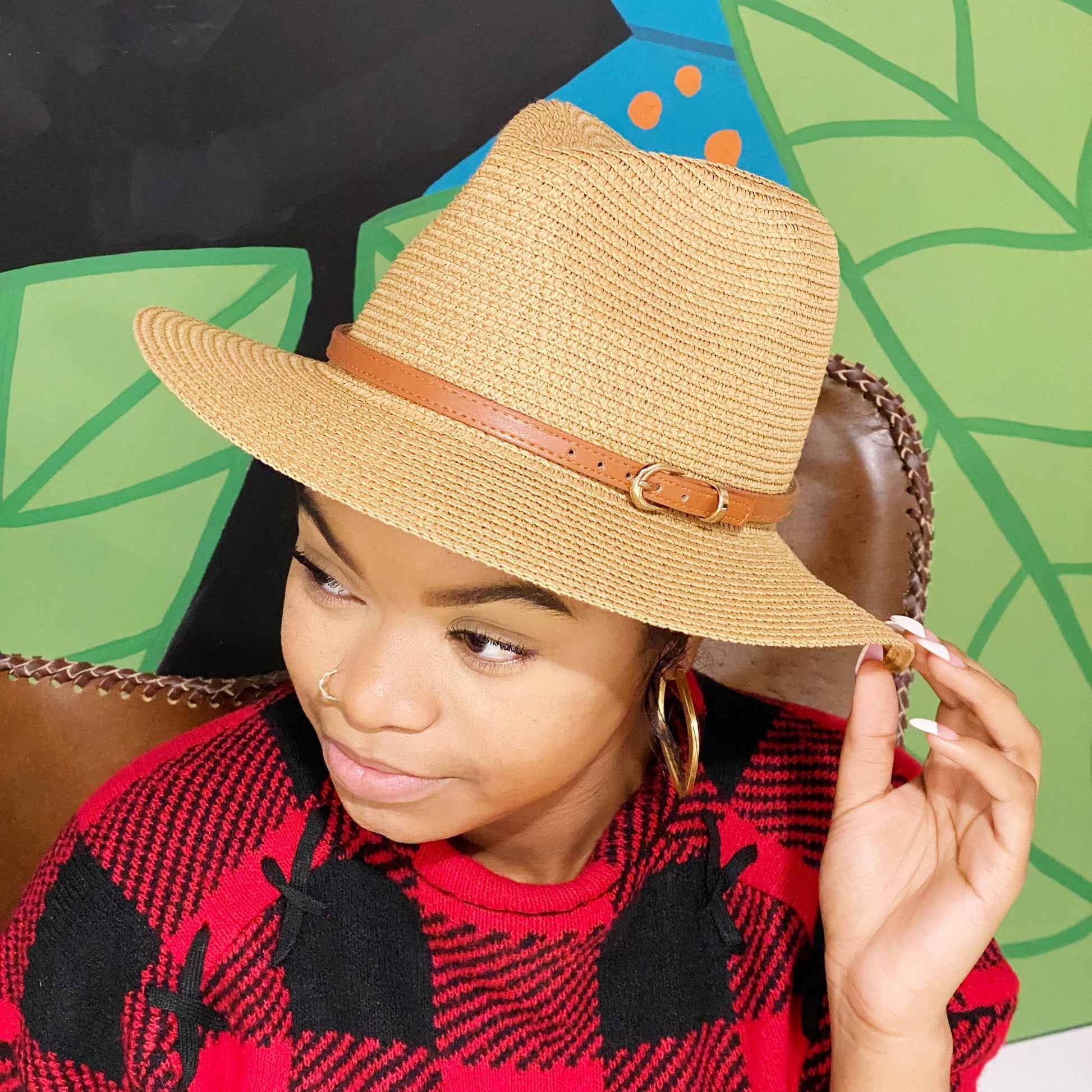 Stylish tan straw fedora hat with a brown leather band, perfect for sunny weather and casual outings.