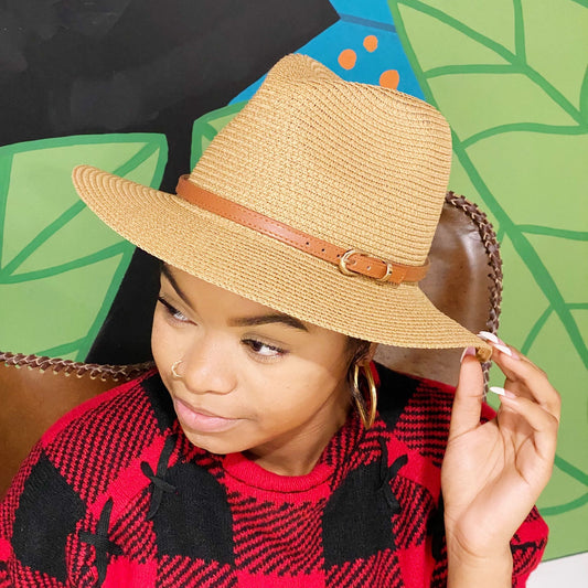 Stylish tan straw fedora hat with a brown leather band, perfect for sunny weather and casual outings.