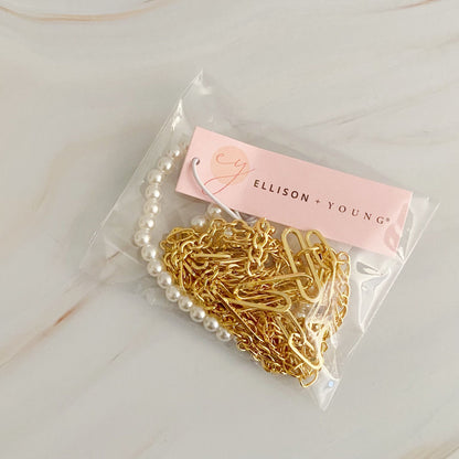 Gold and pearl jewelry necklace set by Ellison + Young, displayed in a clear packaging with a pink logo tag.