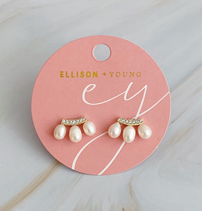 Pearl and rhinestone stud earrings displayed on a pink branded card by Ellison + Young.