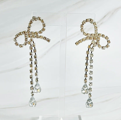 Elegant crystal bow earrings with dangling rhinestones and teardrop gems, perfect for formal occasions or adding sparkle to any outfit.