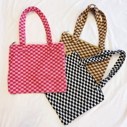 Colorful checked tote bags in pink, brown, and black on a white background, showcasing stylish handles and patterns perfect for casual outings or everyday use.