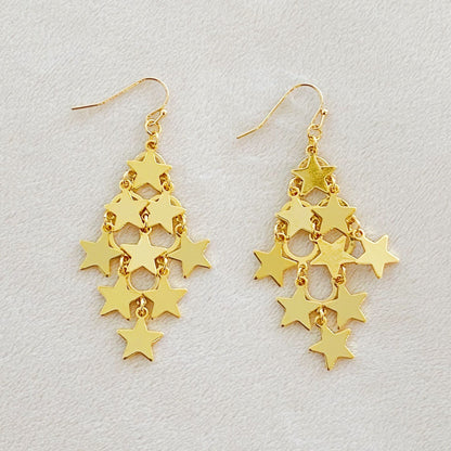 Gold star chandelier earrings featuring a cascading design of shiny, linked star charms.