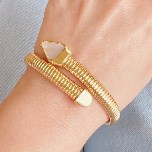 Gold-tone adjustable cuff bracelet featuring a sleek twist design and a geometric stone accent, perfect for adding a stylish touch to any outfit.